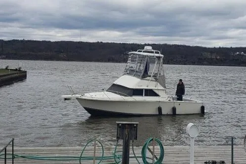 Slide: The Image of 1973 Bertram 28 Flybridge Cruiser on a calm lake with overcast skies. - 3