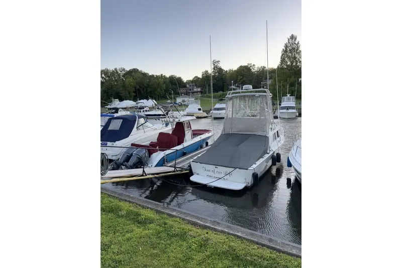 Slide: The Image of 1973 Bertram 28 Flybridge Cruiser docked at a marina with other boats. - 4