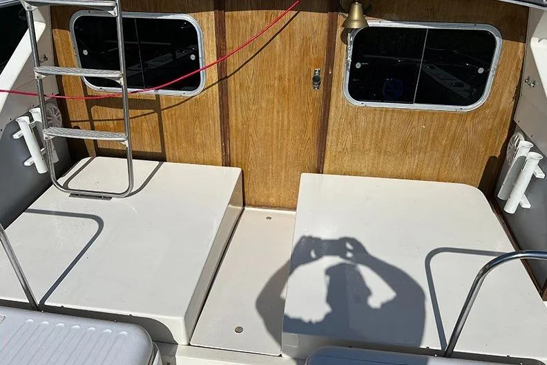 Slide: The Image of 1973 Bertram 28 Flybridge Cruiser deck with ladder and wooden paneling. - 9