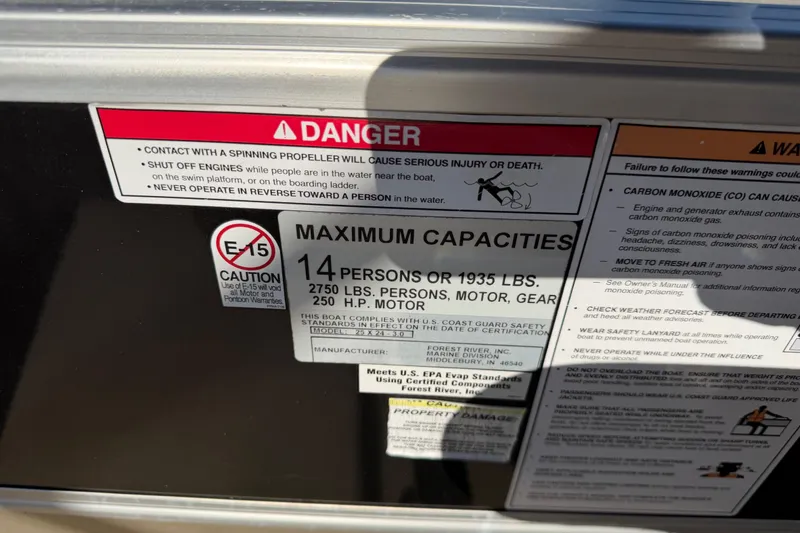 Slide: The Image of Warning labels on a 2020 Berkshire 25SL boat, detailing safety and capacity limits. - 12