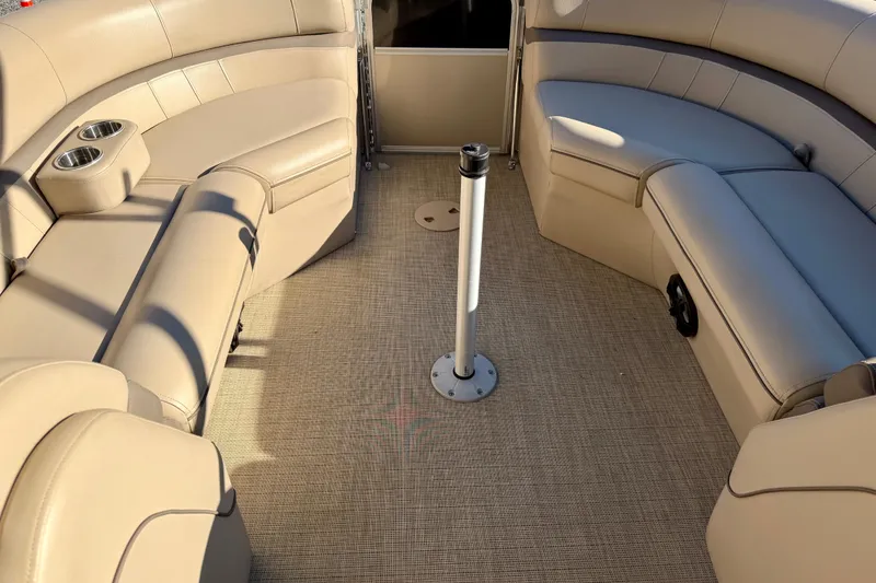 Slide: The Image of Luxurious interior of a 2020 Berkshire 25SL pontoon boat with beige seating and cup holders. - 15