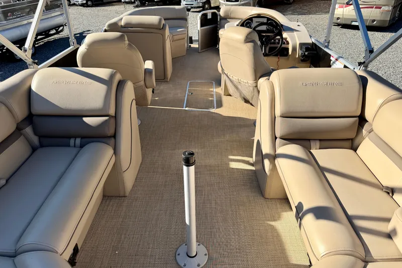 Slide: The Image of 2020 Berkshire 25SL pontoon boat interior with beige seating and steering console. - 7