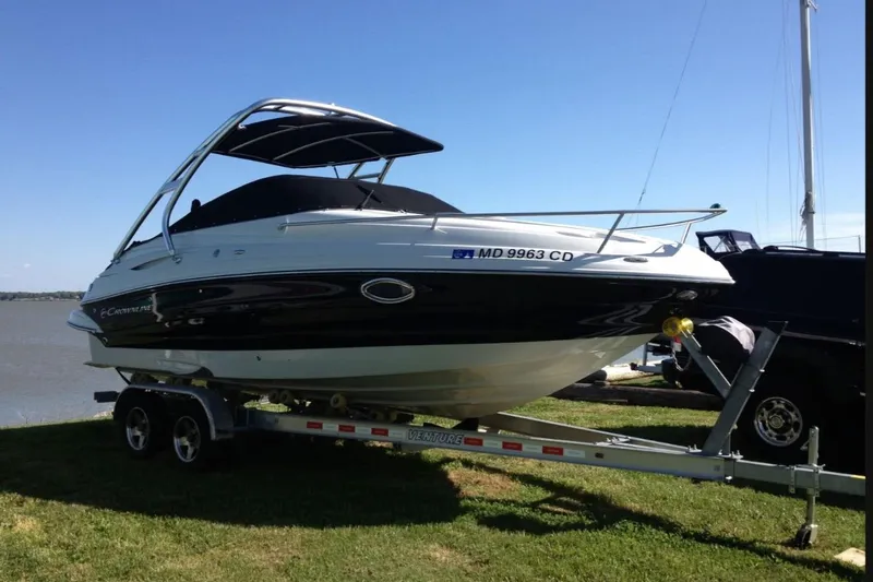 The Image of 2012 Crownline 236 SC boat on trailer by the water, sunny day. - 0