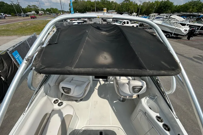 Slide: The Image of 2012 Crownline 236 SC boat interior with seating and canopy, parked outdoors. - 16