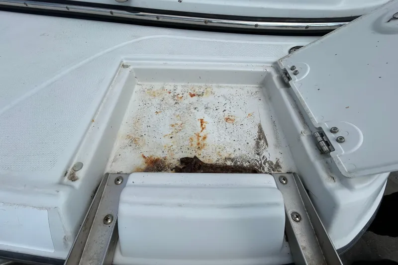 Slide: The Image of Open storage compartment on 2012 Crownline 236 SC boat, showing dirt and rust stains. - 33