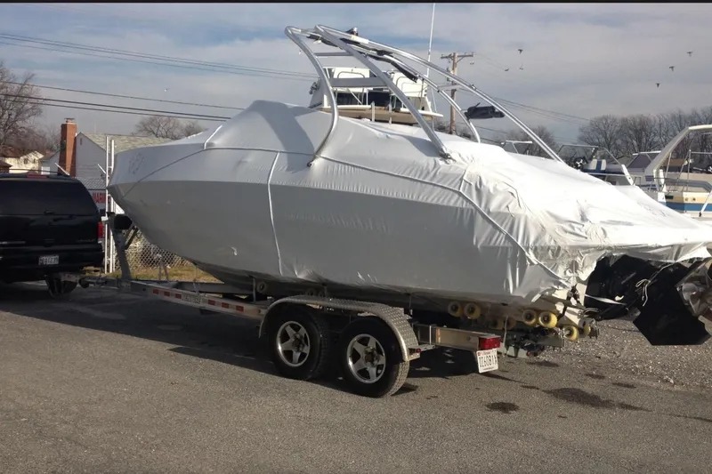 Slide: The Image of 2012 Crownline 236 SC boat covered on trailer, parked outdoors. - 4