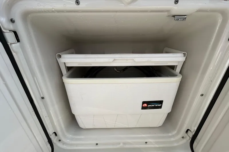 Slide: The Image of White marine cooler inside a 2012 Crownline 236 SC boat compartment. - 46