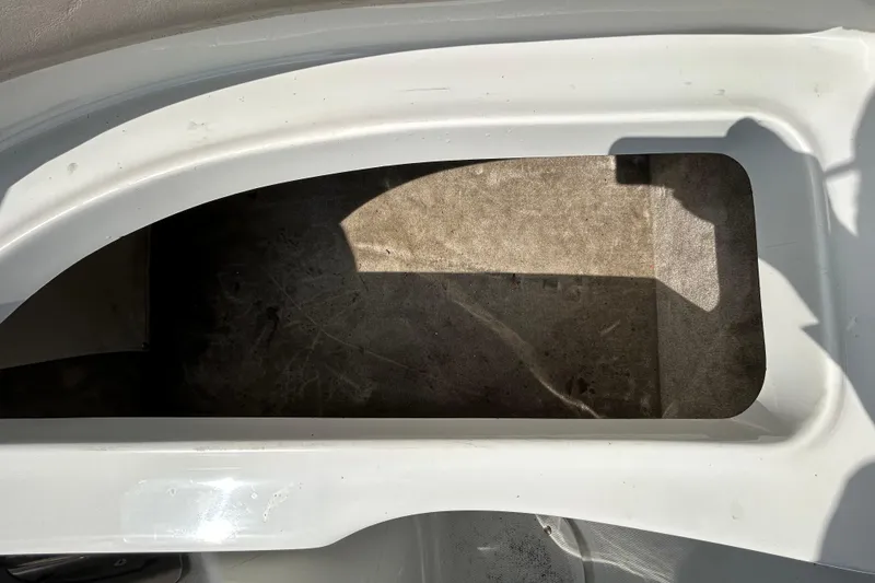Slide: The Image of Storage compartment on a 2012 Crownline 236 SC boat, featuring a clean white finish. - 52