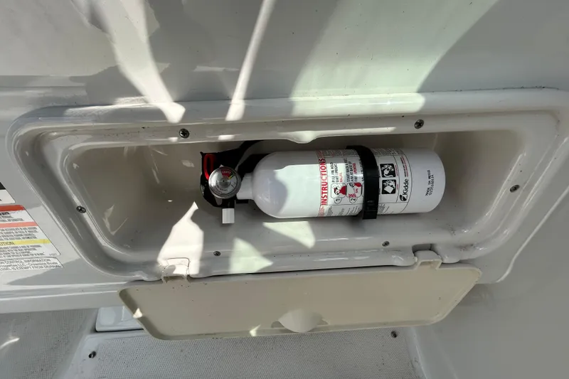 Slide: The Image of Fire extinguisher in a 2012 Crownline 236 SC boat compartment. - 56