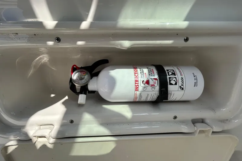 Slide: The Image of Fire extinguisher mounted inside a 2012 Crownline 236 SC boat compartment. - 57