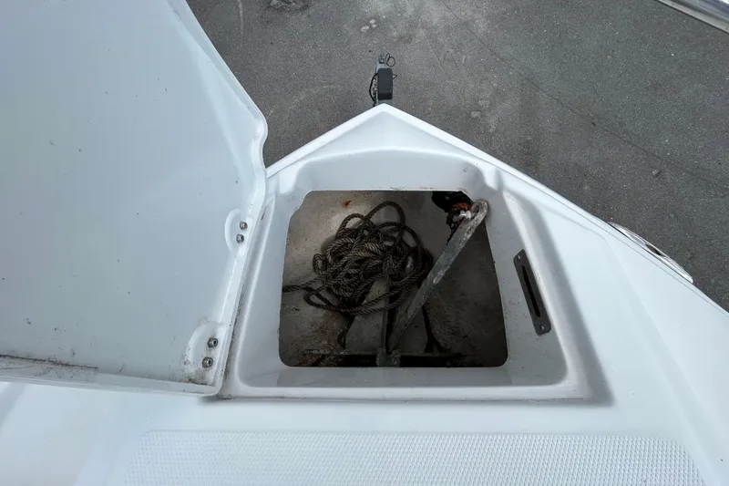 Slide: The Image of Open anchor compartment on 2012 Crownline 236 SC boat, showing rope and anchor. - 65