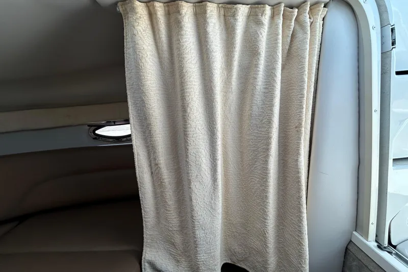 Slide: The Image of Interior cabin of 2012 Crownline 236 SC boat with beige curtain and small window. - 71