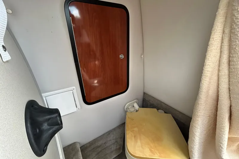 Slide: The Image of Interior cabin of 2012 Crownline 236 SC boat with wooden door and compact amenities. - 73