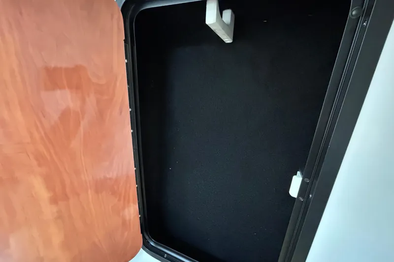 Slide: The Image of Storage compartment in a 2012 Crownline 236 SC boat, featuring a wooden door. - 76
