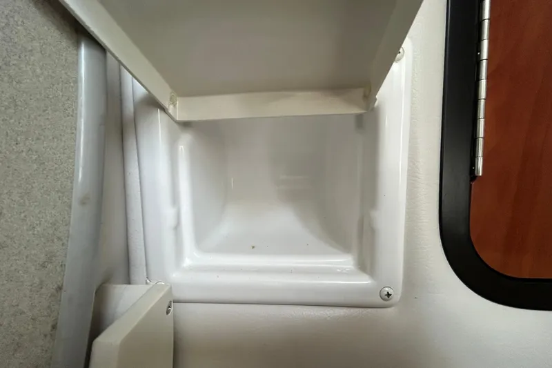 Slide: The Image of Interior compartment of 2012 Crownline 236 SC boat, featuring a white storage area. - 78