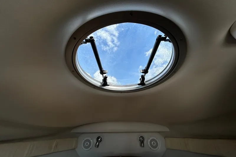 Slide: The Image of Interior view of 2012 Crownline 236 SC boat's porthole with blue sky visible. - 84
