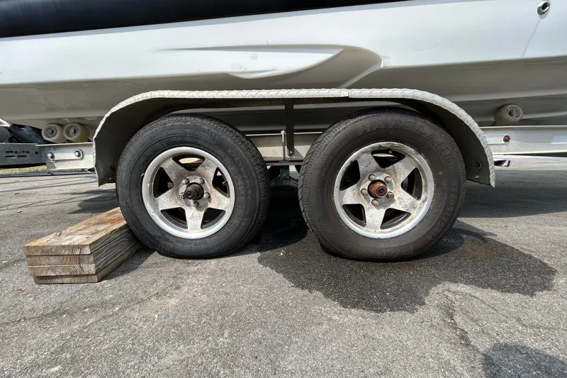 Slide: The Image of Trailer wheels of a 2012 Crownline 236 SC boat on pavement. - 95