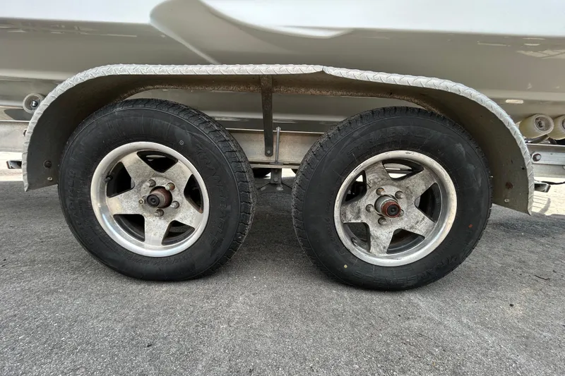 Slide: The Image of Trailer wheels of a 2012 Crownline 236 SC boat on pavement. - 96