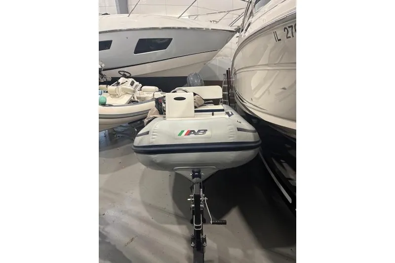 Slide: The Image of 2025 AB Inflatables Mares 12 VSX boat in storage, surrounded by other vessels. - 10