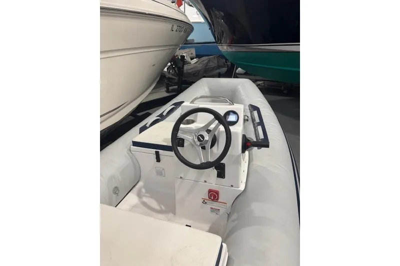 Slide: The Image of 2025 AB Inflatables Mares 12 VSX boat interior with steering wheel and control panel. - 12