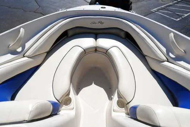 Slide: The Image of 2004 Sea Ray 200 Select boat interior with white and blue cushioned seating. - 10