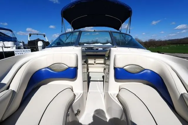 Slide: The Image of 2004 Sea Ray 200 Select boat interior with blue and white seating under clear blue sky. - 12
