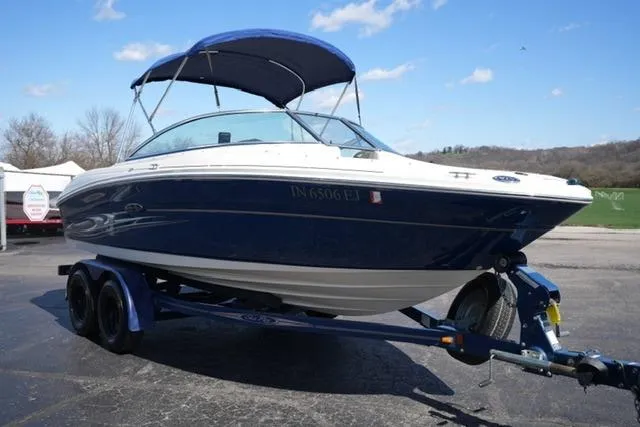 Slide: The Image of 2004 Sea Ray 200 Select boat on trailer, blue and white, parked outdoors. - 3