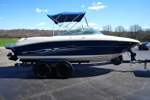 Slide: The Image of 2004 Sea Ray 200 Select boat on trailer, blue and white, with canopy, parked outdoors. - 4