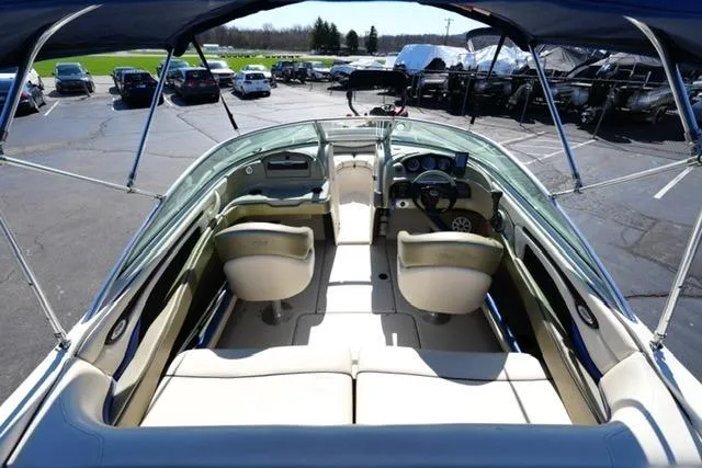 Slide: The Image of 2004 Sea Ray 200 Select boat interior with seating and steering wheel, parked outdoors. - 9