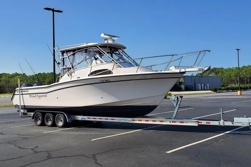 Slide: The Image of 2003 Grady-White Marlin 300 boat on trailer in parking lot, clear sky background. - 12