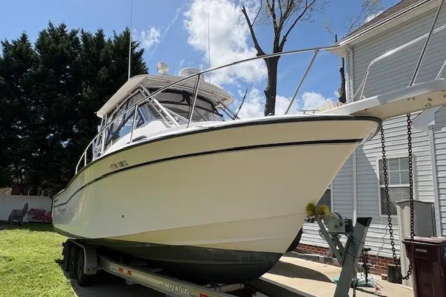Slide: The Image of 2003 Grady-White Marlin 300 boat on trailer, parked beside a house. - 20