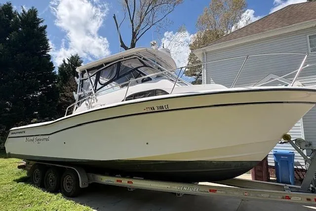 Slide: The Image of 2003 Grady-White Marlin 300 boat on trailer, parked near house, under blue sky. - 21