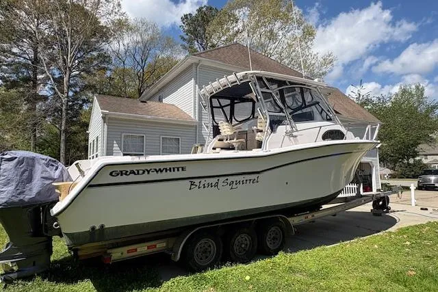 Slide: The Image of 2003 Grady-White Marlin 300 boat on trailer, parked in residential driveway. - 22