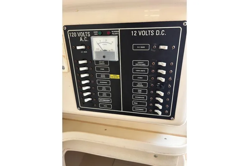 Slide: The Image of Electrical panel on a 2003 Grady-White Marlin 300 boat, showing AC and DC switches. - 27