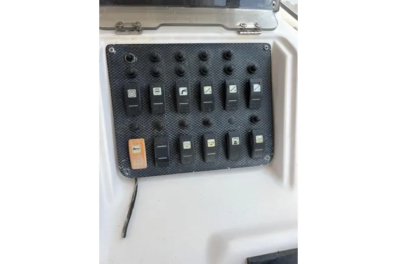 Slide: The Image of Control panel of a 2003 Grady-White Marlin 300 boat with multiple switches. - 36