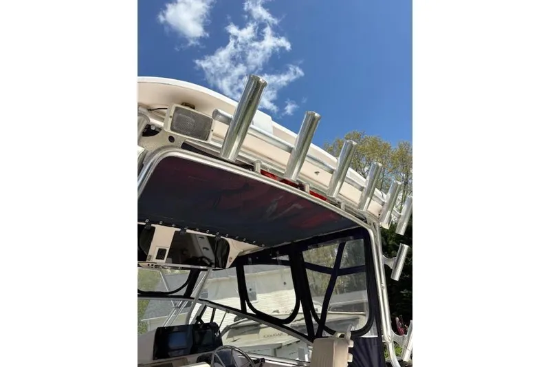 Slide: The Image of 2003 Grady-White Marlin 300 boat with rod holders against a clear blue sky. - 51