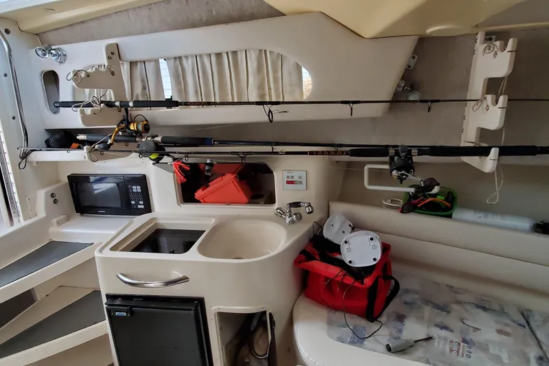 Slide: The Image of Interior of a 2003 Grady-White Marlin 300 boat with fishing gear and kitchenette. - 9
