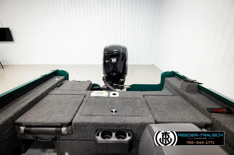 Slide: The Image of 2026 Lund 1775 Adventure Sport boat interior with motor, gray carpet, and storage compartments. - 19