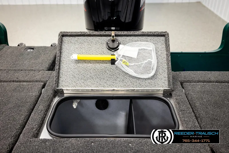 Slide: The Image of 2026 Lund 1775 Adventure Sport boat storage compartment with fishing net and Reeder-Trausch Marine logo. - 21