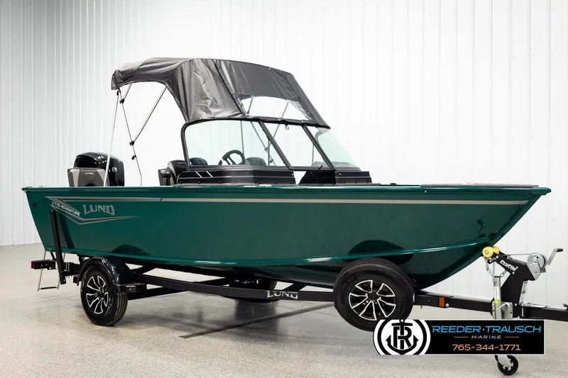 Slide: The Image of 2026 Lund 1775 Adventure Sport boat on trailer, green exterior, displayed indoors. - 3