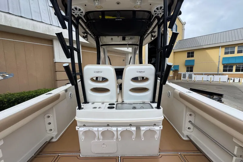 Slide: The Image of 2015 Sailfish 320 CC boat interior with dual seats and fishing rod holders. - 11