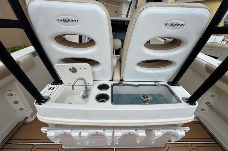 Slide: The Image of 2015 Sailfish 320 CC boat interior with sink, cup holders, and storage compartments. - 16