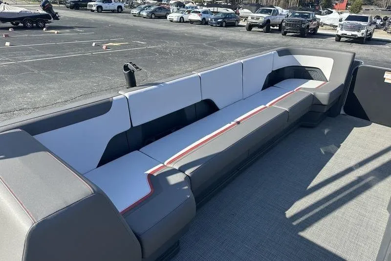 Slide: The Image of 2024 Manitou Cruise 22 Bench Tritoon with spacious seating in a parking lot. - 11