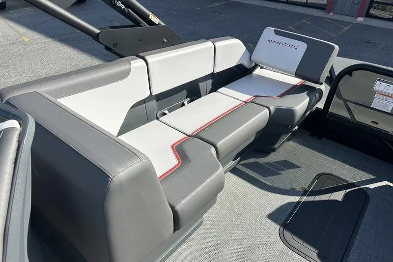 Slide: The Image of 2024 Manitou Cruise 22 Bench Tritoon with sleek gray and white seating design. - 2