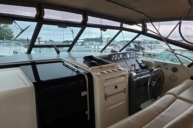 Slide: The Image of 1995 Tiara Yachts 3500 Express cockpit with steering wheel and control panel, docked at marina. - 10