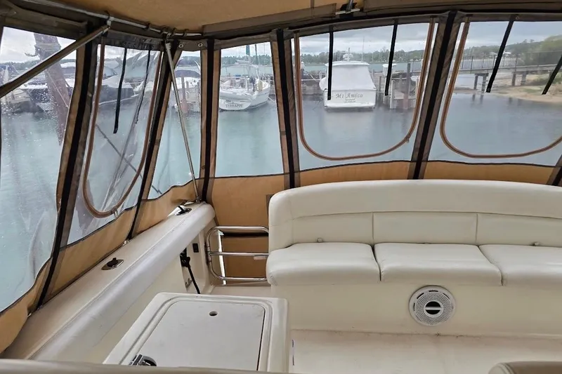 Slide: The Image of Interior view of 1995 Tiara Yachts 3500 Express with white seating and marina backdrop. - 16