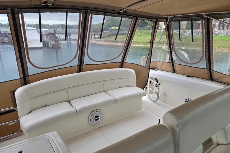 Slide: The Image of Interior of 1995 Tiara Yachts 3500 Express with white seating and marina view. - 17