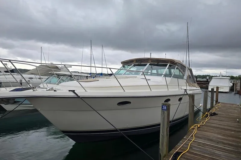 Slide: The Image of 1995 Tiara Yachts 3500 Express docked at marina under cloudy skies. - 21
