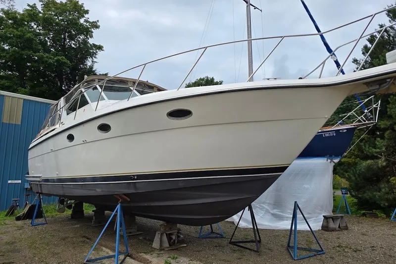 Slide: The Image of 1995 Tiara Yachts 3500 Express boat on stands, outdoor storage setting. - 8