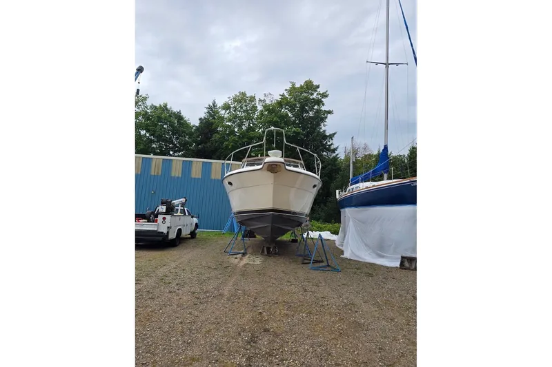 Slide: The Image of 1995 Tiara Yachts 3500 Express on stands, surrounded by trees and a blue building. - 9